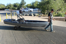 Load image into Gallery viewer, Man pulling FluxJet electric kayak on wheels at boat launch ramp
